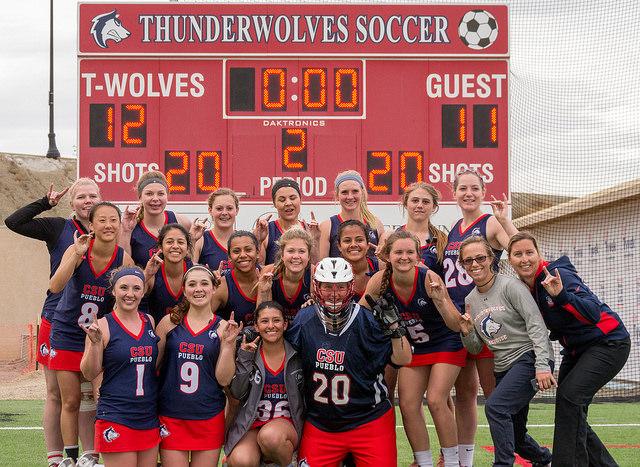 CSU-Pueblo Women's Lacrosse team poses for photos in front of the score board after their win 12-11 win. Photo Credit: Dustin Cox