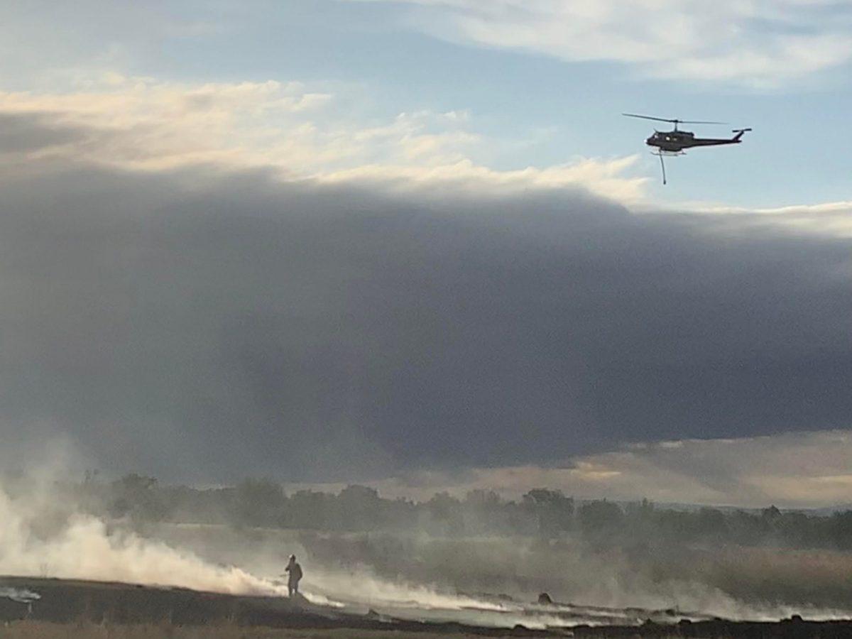 A firefighter stands in the smoke of the June 3 Lake Minnequa Fire while a firefighting helicopter passes overhead. [Today photo/file/Kimmy Reinhardt] 