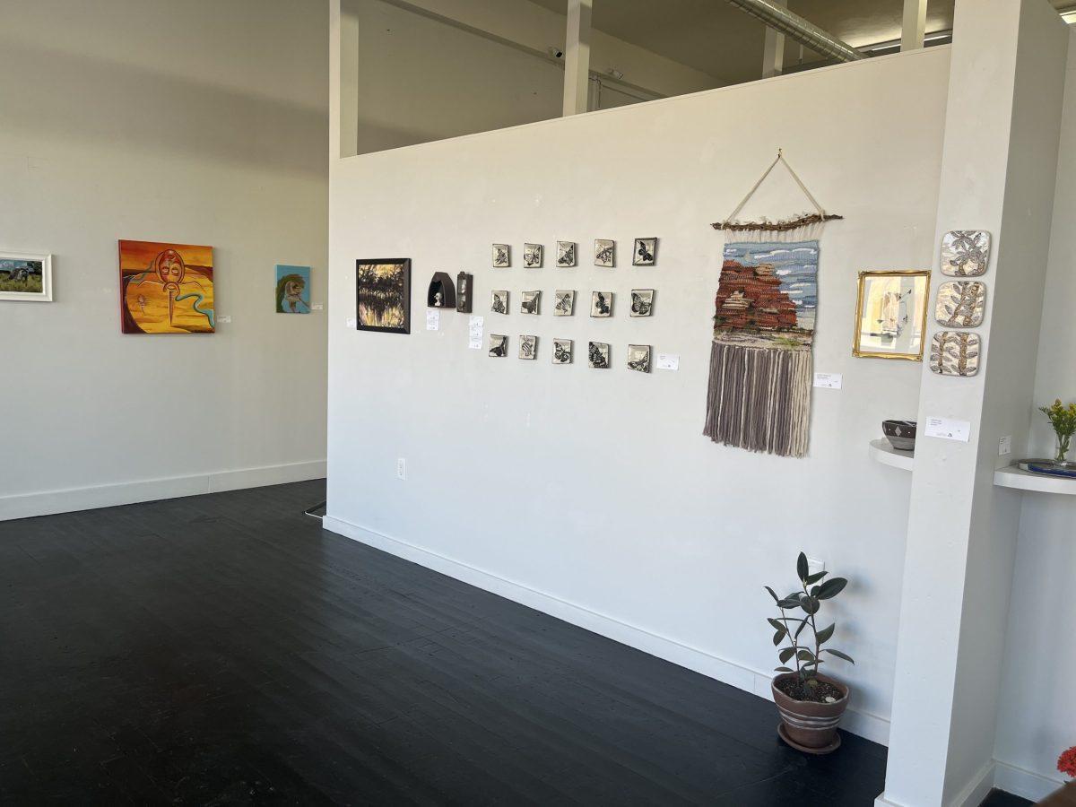 The+Raised+by+Wolves+art+show+and+its+artwork+hanging+on+the+walls.+Photo+by+Holly+Ward.