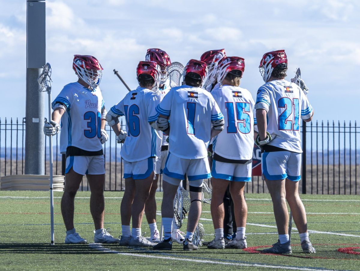 Players of the men’s lacrosse team huddle together during their game at Art and Lorraine Gonzales Stadium on Sunday, Feb. 4.