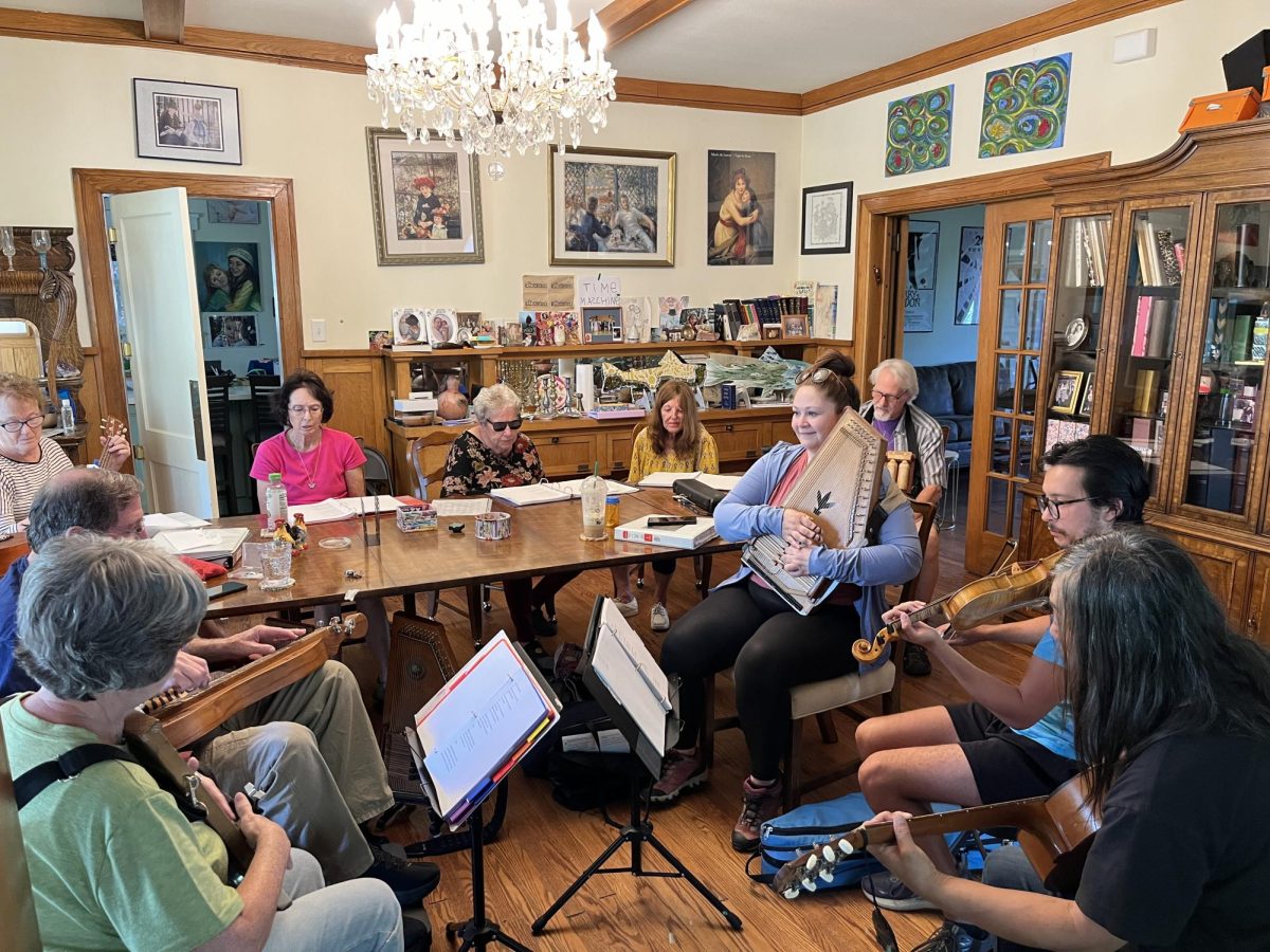 The "Saturday Morning Spasm Band" gathers around a dining room table and performs together. 