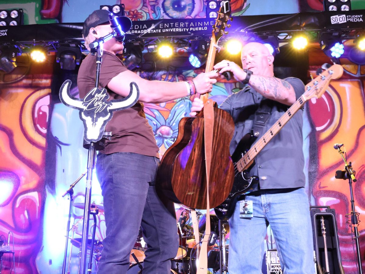 Cody Cozz grabs his guitar on stage from one of his band members at the Steel City Music Showcase on April 11th. 