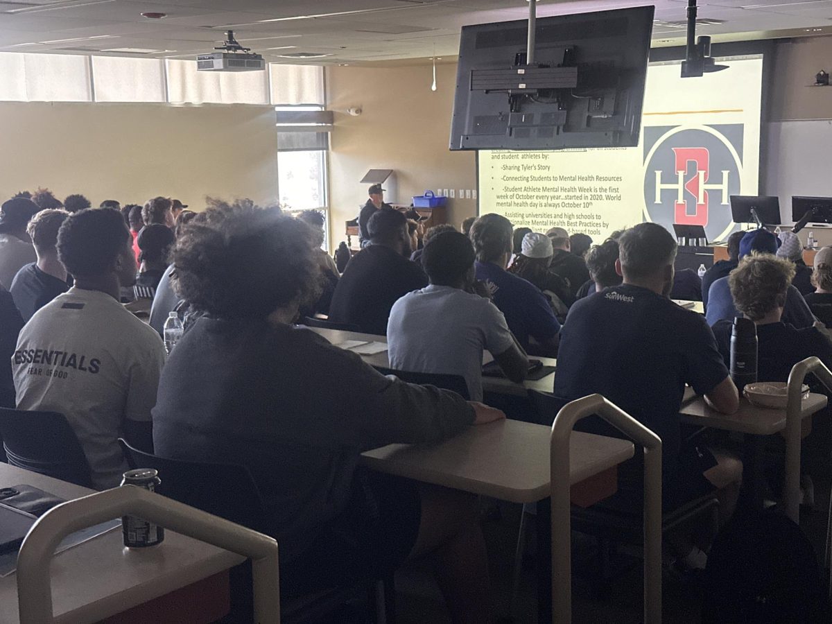 Photo of student athletes watching presentation (photo by Trevor Vigil).